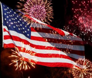 July 4th fireworks in front of American flag