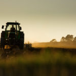 Tractor in sunset plowing the field